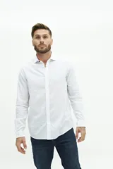 Camisa de lino color beige, de manga larga, corte semi slim y logo bordado en el pecho.