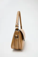 Bolso bandolera color caramelo, con doble asa: una asa larga regulable y una asa de hombro. Tiene bolsillo interior con cierre mediante cremallera metálica y solapa con cierre imantado.