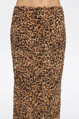 Falda midi de corte recto y ajustado, con estampado animal print en tonos marrones y negros. Presenta goma elástica en la cintura y abertura trasera en el bajo.