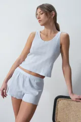 Musculosa celeste con textura acanalada y detalle de moño en el escote.