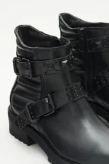 Bota de cuero negra con caña media, tiras cruzadas con hebillas y remaches metálicos, laterales matelaseados y cierre lateral interno.