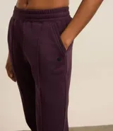 Pantalón deportivo color morado, de algodón y poliéster, con cintura elástica y bolsillos laterales.