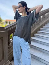 Remera tejida color marrón con hilado 100% algodón y cintas de piedras aplicadas en cuello y mangas.