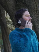 Funda de cuero marrón para iPhone con tarjetero en la parte posterior y logo de la marca Sierra Mora grabado en la parte inferior.