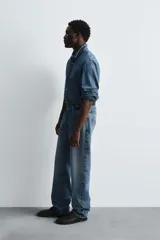 Pantalón de jean celeste de corte recto, con cinco bolsillos y cierre frontal con botones.