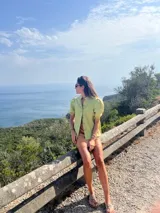 Camisa color ladrillo confeccionada en lino, con cuello mao, mangas cortas abullonadas y cierre frontal con botones.