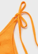 Bombacha de bikini color naranja con bordado de flores y cierre de lazos laterales.