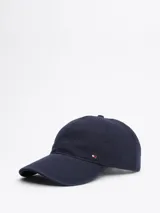 Gorra de béisbol azul marino de Tommy Hilfiger, confeccionada en tejido de espiga de algodón. Presenta diseño de seis paneles, botón en la parte superior, ojales de ventilación, hebilla de ajuste metálica en la parte trasera y logo esmaltado de Tommy en la parte delantera y la hebilla.