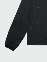 Chaqueta negra con capucha y cierre frontal con cremallera. Logotipo de Moncler en el borde de la capucha.