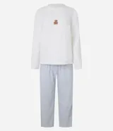 Pijama largo de sherpa color blanco, compuesto por un buzo de cuello redondo y mangas largas con estampa de una carita sonriente y un pantalón con estampa de lunares.