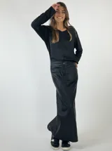 Falda midi color plateado metalizado, de corte recto con tajo en la espalda. Presenta detalles de costura que simulan bolsillos traseros.