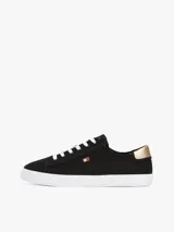 Zapatillas Tommy Hilfiger de lona negra con suela blanca de goma y talón dorado metalizado.