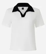 Blusa blanca acanalada de rib con cuello polo negro contrastante y mangas cortas.