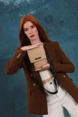 Bandolera tipo phone bag pequeña, color marrón claro, con correa de galón regulable. Tiene un compartimento principal y un bolsillo adicional con tapa.