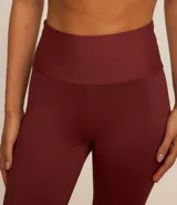 Pantalón deportivo tipo legging confeccionado en microfibra color bordó, con corte ajustado hasta la pantorrilla y terminación acampanada con abertura lateral.
