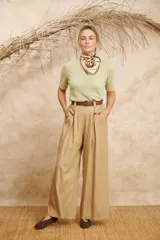 Pantalón ancho color beige de lino con cinto y pretina con elástico en la parte de atrás.