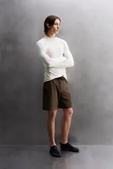 Camiseta de surf compresiva slim fit confeccionada en tejido técnico muy elástico y ligero. Con factor de protección ultravioleta 40+, cuello subido, manga larga, costuras planas y acabados combinados a contraste.