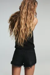 Short de jean de tiro alto, color celeste claro desgastado, con roturas grandes y deshilachado en el bajo. Presenta cinco bolsillos y cierre frontal con botón metálico.