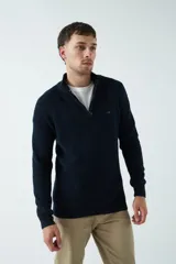 Sweater básico color beige de punto acanalado, con medio cierre frontal, cuello alto y logo bordado en el pecho.