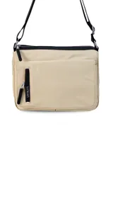 Bandolera color beige de nylon, con correa larga negra regulable. Tiene un bolsillo delantero con tapa, dos bolsillos internos (uno con cierre) y un bolsillo trasero.