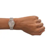 Reloj Skagen Signatur Lille para mujer con caja redonda de acero inoxidable color oro rosa, esfera gris con agujas e indicadores minimalistas y correa de cuero gris.