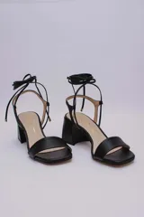 Sandalias rojas de cuero con tiras finas para atar al tobillo y tacón cuadrado.