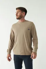 Remera color marrón de manga larga, con bolsillo en el pecho y logo de la marca en etiqueta sobre el bolsillo.
