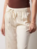 Pantalón palazzo color crema, marca Nanette, con pretina elastizada, lazo de ajuste y bolsillos delanteros.