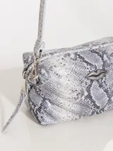 Crossbody de tamaño pequeño en cuero pitón y vacuno, con cierre metálico y forro de tejido jacquard. Incluye un bolsillo plaqué y correa regulable.