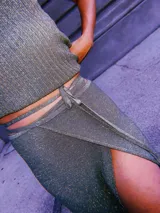 Falda larga cruzada color crudo, confeccionada en tejido de punto con lurex y viscosa.