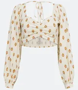 Blusa cropped de lino con escote corazón, lazada en la espalda, manga larga abullonada y estampado de anacardos.