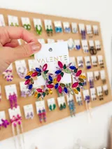 Aros colgantes con forma circular, con incrustaciones de gemas de diferentes colores.