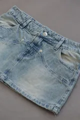 Minifalda de jean celeste con bolsillos delanteros y traseros.