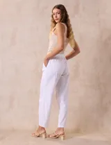 Pantalón largo de lino y rayón a rayas verticales grises y blancas. Tiene pretina elastizada con lazo de ajuste, bolsillos delanteros y traseros.