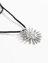 Collar con cordón negro ajustable y dije dorado con forma de sol texturizado.