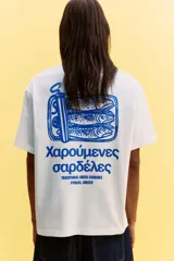 Remera blanca de algodón de peso medio con cuello redondo ribeteado, hombros caídos y bajo recto. Tiene un estampado pequeño en el lado izquierdo del pecho con texto en griego de color celeste. Corte holgado.