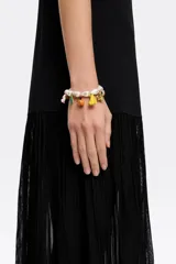 Pulsera de perlas irregulares con charms colgantes de motivos selváticos y cierre de mosquetón dorado.