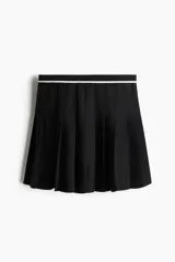 Minifalda negra tableada de punto con cintura elástica a rayas horizontales blancas y negras.