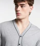 Conjunto de pijama largo confeccionado en media malla. Incluye una camisa de manga larga con botones y un pantalón con cintura elástica. La camisa tiene un ribete en contraste en la botonadura frontal.