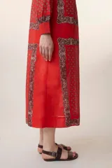 Vestido largo rojo con estampado floral, cuello mao, mangas largas y corte evasé.