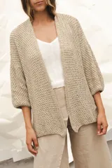 Saco tejido a mano color beige, de silueta oversize con mangas caídas y tajos laterales.