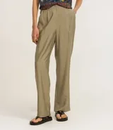 Pantalón de viscosa color beige, de corte recto, con bolsillos laterales y cierre de botón y cremallera.