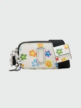 Bandolera Marc Jacobs modelo The Wild Daisy Snapshot, color crema con estampado de flores de colores, logo plateado en el frente y correa ancha ajustable con monedero extraíble.