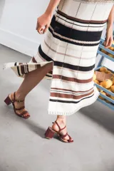 Vestido largo de tejido calado con rayas horizontales en color crudo, azul marino y rojo. Tiene tajo lateral y logo bordado en la manga.