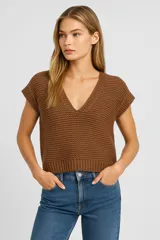 Musculosa color crema de acrílico con punto canalé, corte holgado y escote en V profundo.