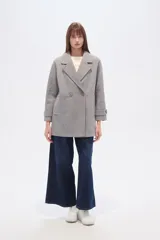 Tapado de poliéster color gris con cuello de solapa y cierre frontal de botones. Cuenta con mangas largas y un diseño de corte recto.