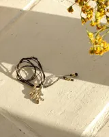 Collar con dije de bronce macizo con forma orgánica o de coral, suspendido de un hilo de seda natural color naranja.