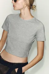 Camiseta de manga corta con cuello redondo, corte cropped y patrón de rayas horizontales en azul marino y blanco.