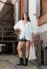 Blusa blanca de mangas cortas con volados, escote en V y lazo de ajuste.