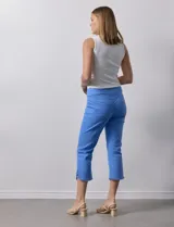 Pantalón capri azul de algodón. Delantera con bolsillos simulados, trasera con bolsillos aplicados. Pretina ancha elastizada, corte recto. Ruedo con aplique entrelazado, tachas y terminación desflecada.